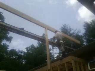 Carpenter setting a ridge beam over a new addition frame — Ice Dam Removal by Roofing Brothers in Zirconia