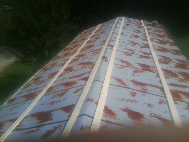Rusted metal roof panels with new wood purlins before replacement — Storm Damage Roof Repair in Zirconia by Roofing Brothers