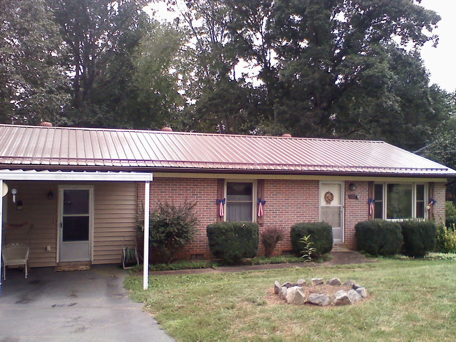 Bronze metal roof and carport on a brick ranch home — Roof Repair work by our crew in Zirconia